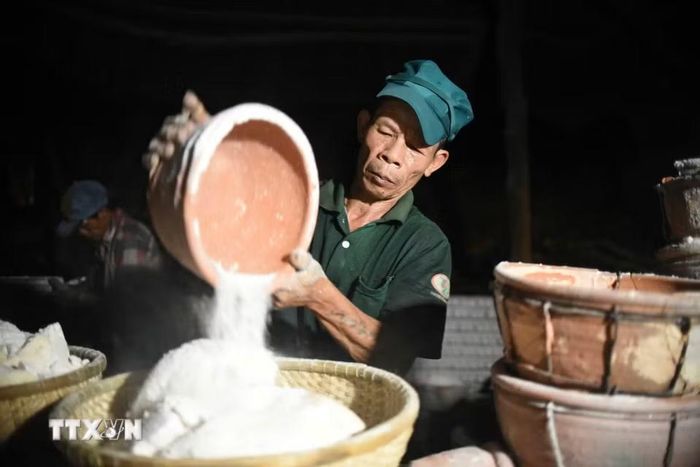 Diêm dân thu sản phẩm muối hầm. (Ảnh: Tường Quân/TTXVN)