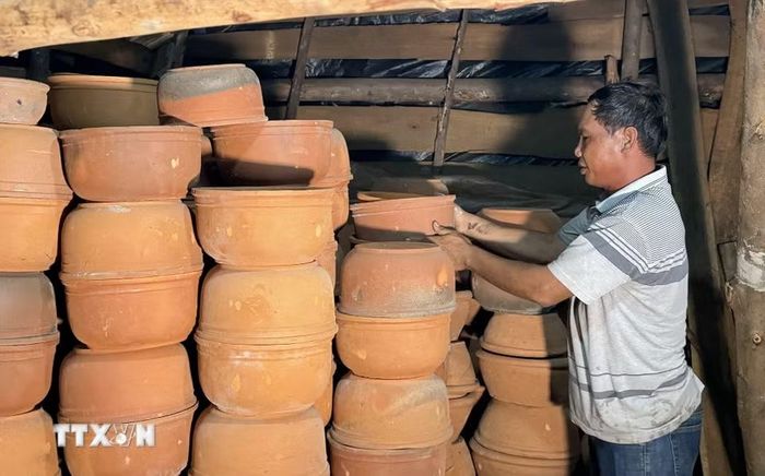 Diêm dân làng nghề Tuyết Diêm chuẩn bị chậu đựng muối hạt trước khi cho vào lò hầm. (Ảnh: Tường Quân/TTXVN)