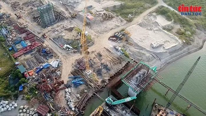 Hệ thống cọc ván thép và thiết bị thi công phục vụ xây dựng trụ cầu sát mép sông.