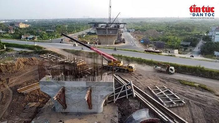 Cần cẩu hỗ trợ thi công kết cấu trụ cầu tại khu vực đường dẫn.