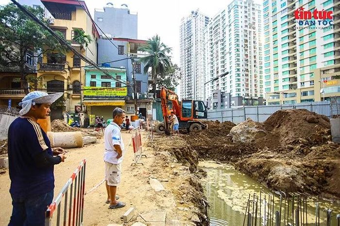 Công trường với các hố đào và máy xúc hoạt động ngay sát khu dân cư,.