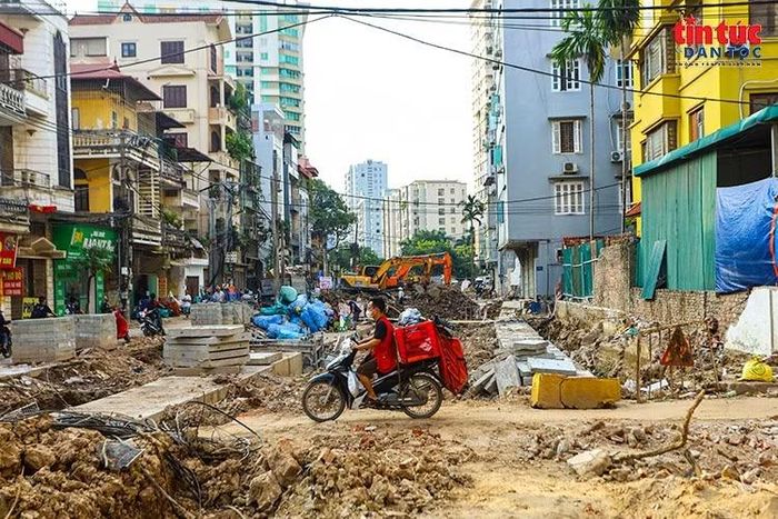 Người dân di chuyển qua khu vực ngõ 381 Nguyễn Khang, nơi nhiều hạng mục đang thi công.