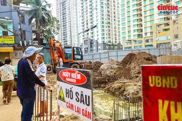Hàng rào và biển cảnh báo nguy hiểm được bố trí quanh hố đào sâu.