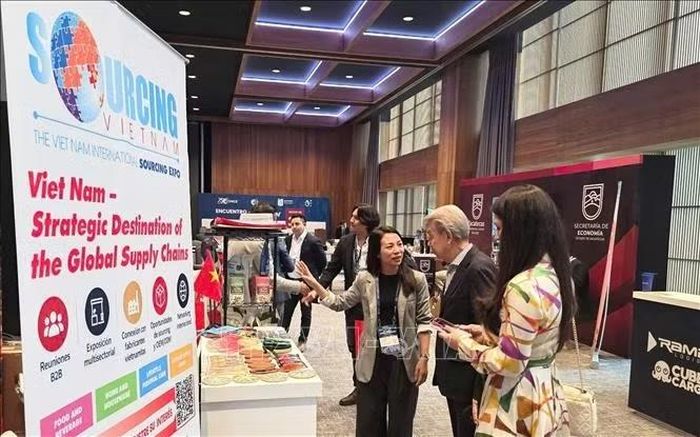 Tham tán Thương mại Việt Nam tại Mexico Nguyễn Thị Trang giới thiệu gian hàng Việt Nam tại Đại hội Ngoại thương Mexico lần thứ 32 (Congreso COMCE 32). Ảnh: TTXVN phát