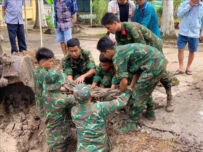 Lực lượng làm nhiệm vụ thực hiện quy tập hài cốt liệt sĩ vừa được tìm thấy tại Nghĩa trang tạm Tân Bằng. Ảnh: Vĩnh Nghị/TTXVN phát