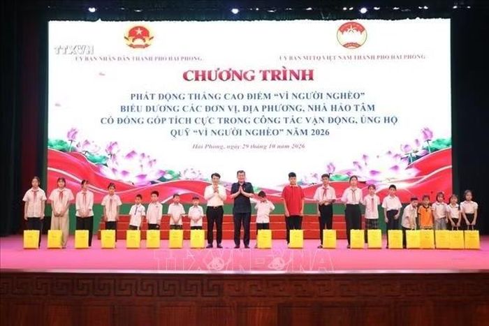 Ban tổ chức trao quà tặng học sinh có hoàn cảnh khó khăn. Ảnh: Mạnh Minh/TTXVN