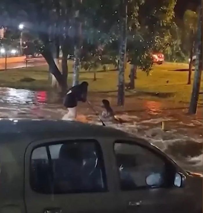 Cô gái cố cứu bạn mình khỏi bị nước lũ cuốn trôi. (Nguồn: Newsflash)