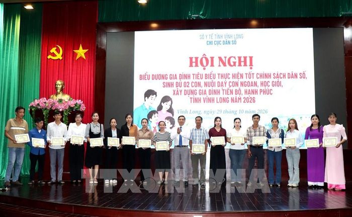 Trao Giấy khen biểu dương gia đình tiêu biểu thực hiện tốt chính sách dân số. Ảnh: Lê Thúy Hằng - TTXVN