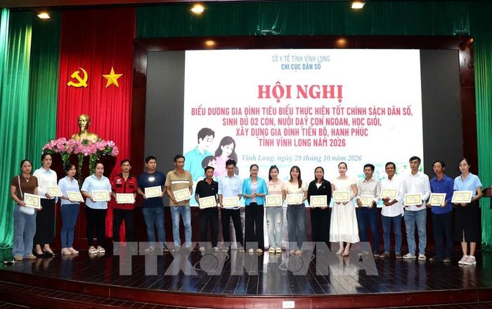 Trao Giấy khen biểu dương gia đình tiêu biểu thực hiện tốt chính sách dân số. Ảnh: Lê Thúy Hằng - TTXVN