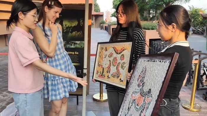 Nhóm “Vụn Gốm Khảm Hoa” giới thiệu sản phẩm tới khách hàng nước ngoài. (Ảnh: NVCC