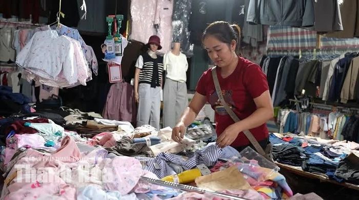Trong lúc đợi khách, chị Lê Thị Bé tranh thủ sắp xếp lại các mặt hàng.