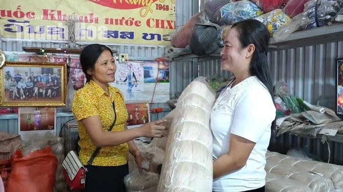 Chị Đỗ Thị Hạnh giới thiệu mặt hàng cho một vị khách người Lào.