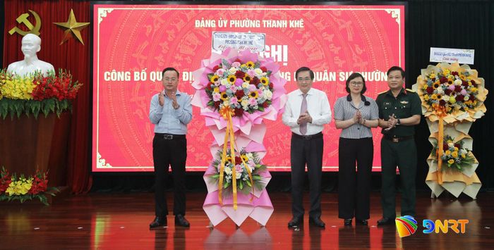 Phó Bí thư Thường trực Đảng ủy phường Thanh Khê Huỳnh Sơn Hải (ngoài cùng bên trái) tặng hoa chúc mừng Đảng bộ Quân sự phường. Ảnh: ĐẮC MẠNH