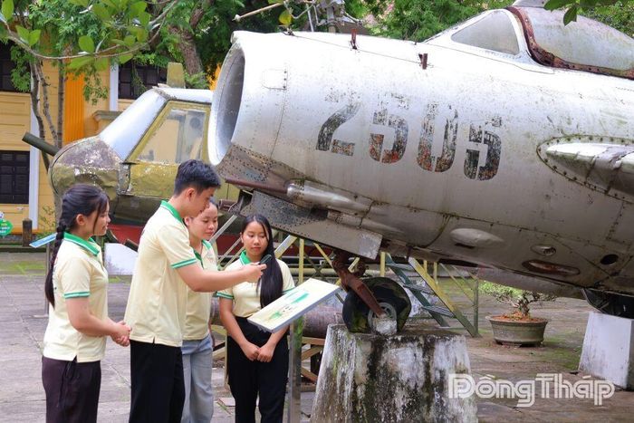 Khách tham quan quét mã QR tìm hiểu hiện vật trưng bày ngoài trời tại Bảo tàng Đồng Tháp, cơ sở 2.