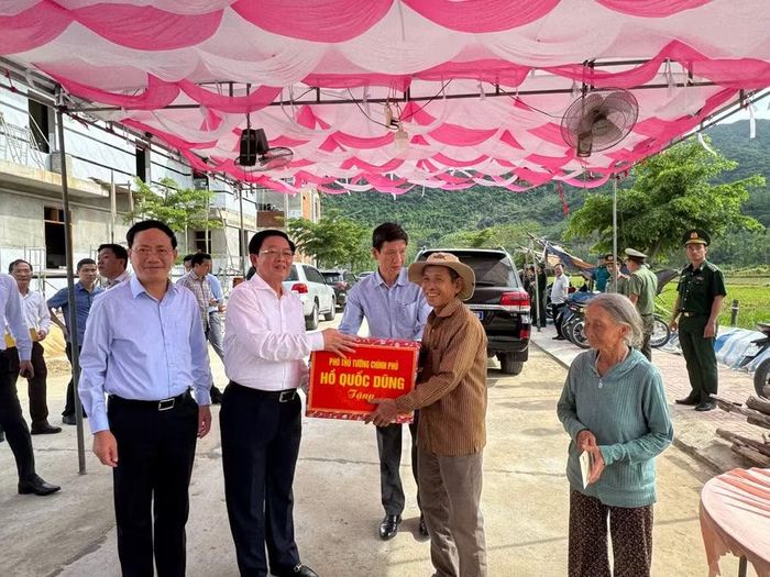  Phó Thủ tướng Hồ Quốc Dũng (thứ 2 từ trái sang) tặng quà cho các hộ gia đình chính sách ở khu tái định cư Núi Cấm. Ảnh: Nguyễn Hân 