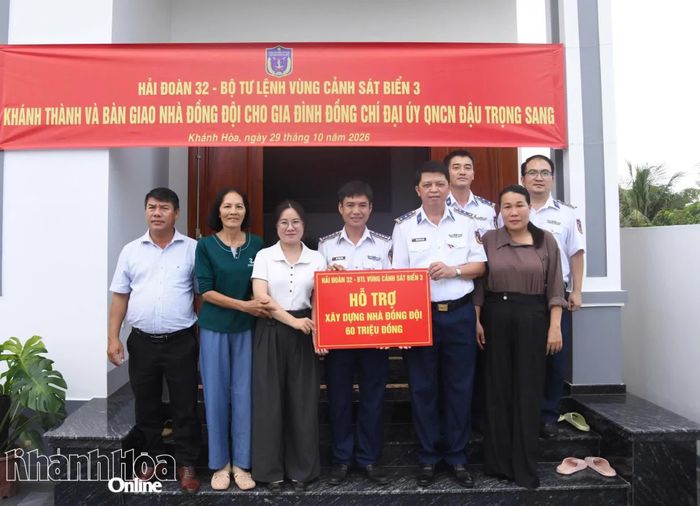 Lãnh đạo Hải đoàn 32 trao bảng tượng trưng số tiền hỗ trợ xây dựng nhà cho gia đình.