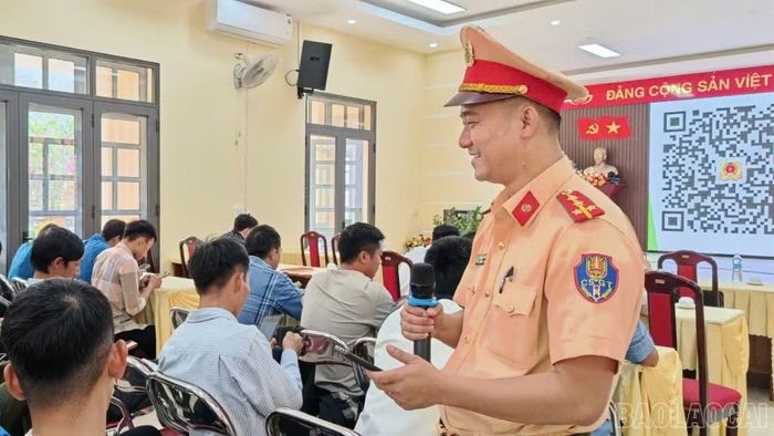 Cán bộ Đội Cảnh sát giao thông đường bộ số 3 hướng dẫn người tham gia quét mã QR để làm bài kiểm tra kiến thức pháp luật về giao thông đường bộ.