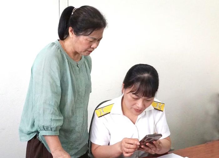 Cán bộ Thuế cơ sở 7 hướng dẫn người nộp thuế sử dụng ứng dụng eTax Mobile.
