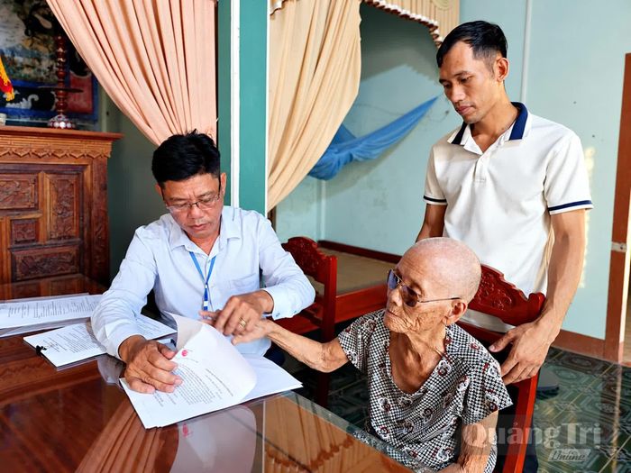 Cán bộ Trung tâm Phục vụ hành chính công xã Mỹ Thủy đến tận nhà hỗ trợ cụ Phan Thị Dỏ, thôn Hải Dương thực hiện thủ tục chứng thực hợp đồng tặng cho quyền sử dụng đất - Ảnh: L.A