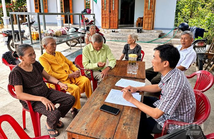 Cán bộ Trung tâm Phục vụ hành chính công xã Nam Hải Lăng hướng dẫn, hỗ trợ người cao tuổi tìm hiểu và thực hiện thủ tục hành chính ngay tại nhà - Ảnh: L.A