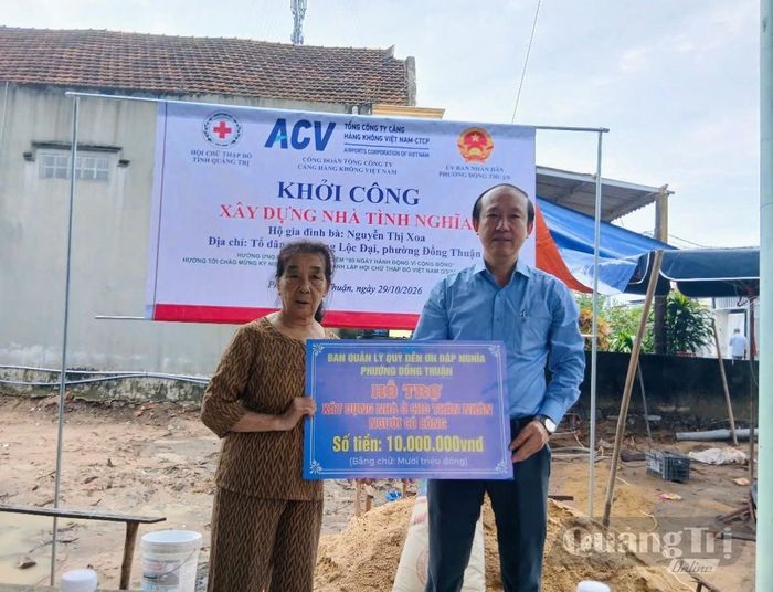 Đại diện lãnh đạo phường Đồng Thuận trao bảng tượng trưng số tiền 10 triệu đồng hỗ trợ xây dựng nhà ở cho thân nhân người có công - Ảnh: H.Đ
