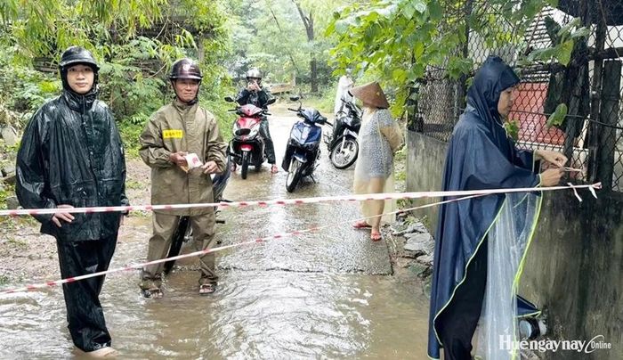 Lực lượng chức năng giăng dây hạn chế việc di chuyển ở một số tuyến đường bị ngập. Ảnh: Nam Anh