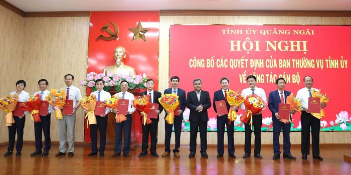 Bí thư Tỉnh ủy Quảng Ngãi Hồ Văn Niên trao quyết định và tặng hoa chúc mừng các cán bộ được điều động, luân chuyển.