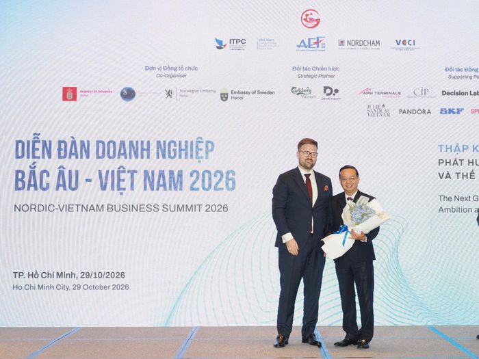 Chủ tịch Hiệp hội Doanh nghiệp Bắc Âu tại Việt Nam Thue Quist Thomasen (bên trái) tặng hoa Phó Chủ tịch UBND TPHCM Bùi Minh Thạnh tại Diễn đàn Doanh nghiệp Bắc Âu – Việt Nam 2026