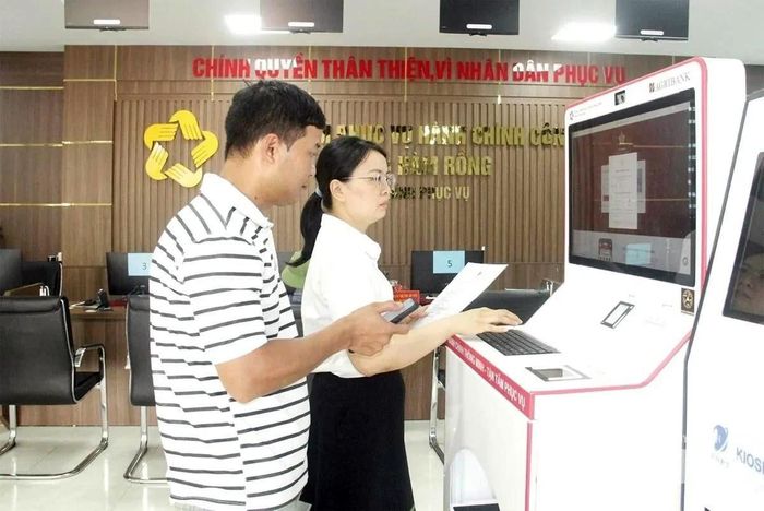 Công chức Trung tâm Phục vụ hành chính công phường Hàm Rồng, tỉnh Thanh Hóa hướng dẫn công dân sử dụng Kiosk thông minh trong giải quyết thủ tục hành chính. Ảnh: Tố Phương
