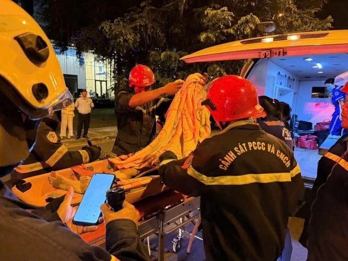 Nạn nhân được đưa lên xe đến bệnh viện cấp cứu.