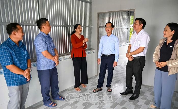 Phó Bí thư Tỉnh uỷ, Chủ tịch Uỷ ban MTTQ Việt Nam tỉnh Cà Mau Hồ Thanh Thuỷ thăm hỏi đời sống gia đình bà Phạm Kiều Thơ (thứ ba từ trái qua), ấp Ðất Sét, xã Phú Mỹ, hộ vừa được hỗ trợ xây dựng nhà Ðại đoàn kết.