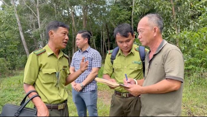 Lực lượng chức năng vận động người dân ký cam kết di dời ra khỏi đất vi phạm. (Ảnh: Dung Hoàng).