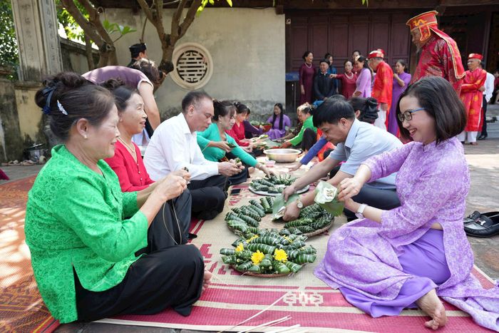 Hoạt động gói bánh tẻ trong khuôn viên đình Đại Phùng. Ảnh: Thiên Tú