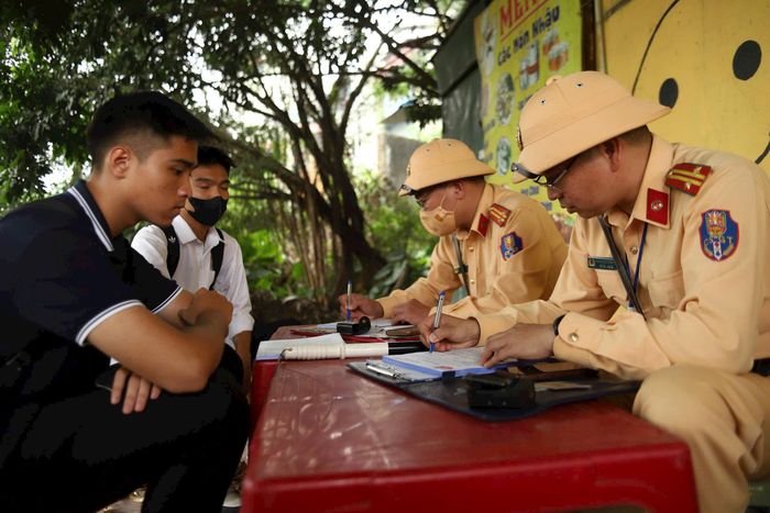 Lực lượng chức năng xử phạt học sinh vi phạm giao thông. Ảnh: Phạm Công