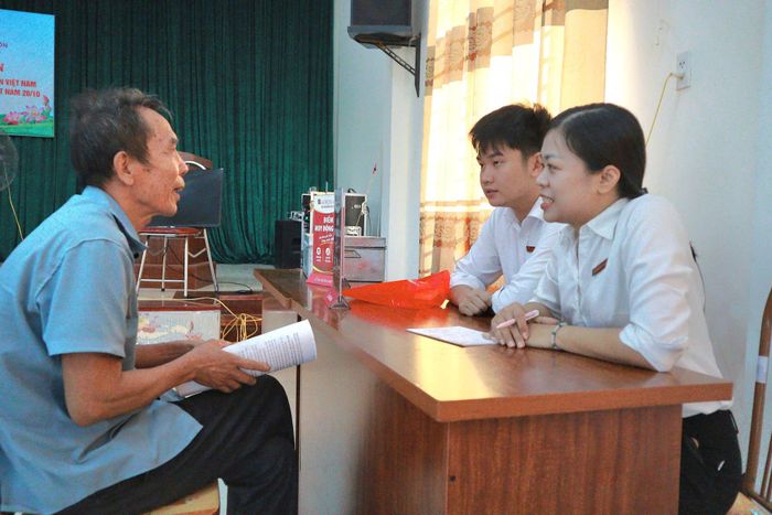 Đại diện Chi nhánh Agribank Phúc Thọ, điểm giao dịch Ngọc Tảo, tư vấn cho người dân gửi tiết kiệm tại ngân hàng. Ảnh: Nguyễn Mai