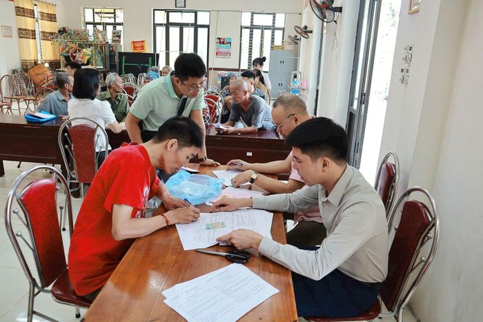 Các hộ có đất thu hồi thực hiện thủ tục nhận tiền bồi thường, hỗ trợ giải phóng mặt bằng. Ảnh: Nguyễn Mai