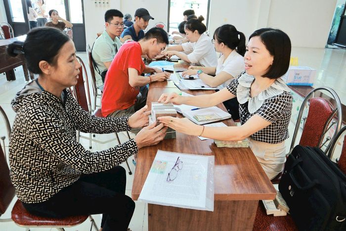 Người dân nhận tiền bồi thường, hỗ trợ giải phóng mặt bằng dự án đường Tam Hiệp, Hiệp Thuận, Liên Hiệp đi tỉnh lộ 420. Ảnh: Nguyễn Mai