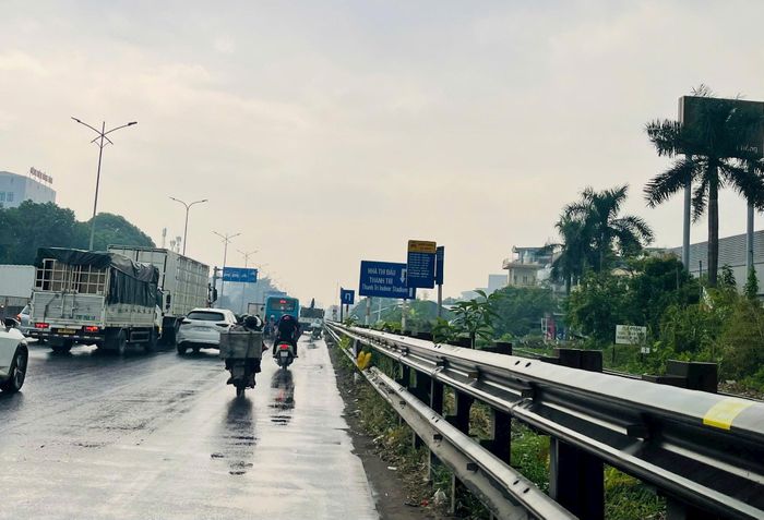 Một điểm chờ xe buýt trên Quốc lộ 1A chưa có mái che và ghế ngồi, khiến người dân thiếu chỗ nghỉ khi chờ phương tiện giữa khu vực có mật độ giao thông đông đúc. Ảnh: PV
