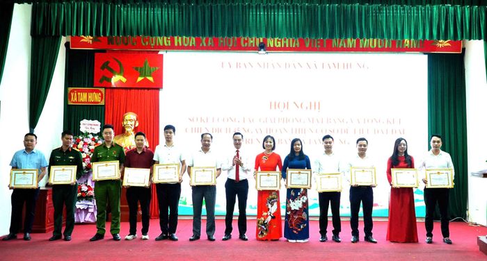 Bí thư Đảng ủy, Chủ tịch HĐND xã Tam Hưng Bùi Văn Sáng trao thưởng tặng các tập thể. Ảnh: Bình Minh 