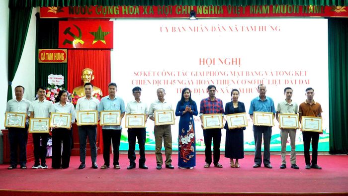 Phó Bí thư Thường trực Đảng ủy xã Tam Hưng Nguyễn Thị Bích Thủy trao thưởng tặng các tập thể. Ảnh: Bình Minh 