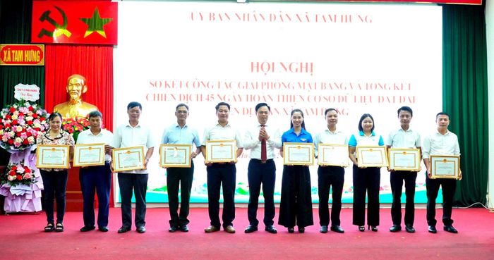 Chủ tịch UBND xã Tam Hưng Bùi Đình Thái trao thưởng tặng các tập thể. Ảnh: Bình Minh
