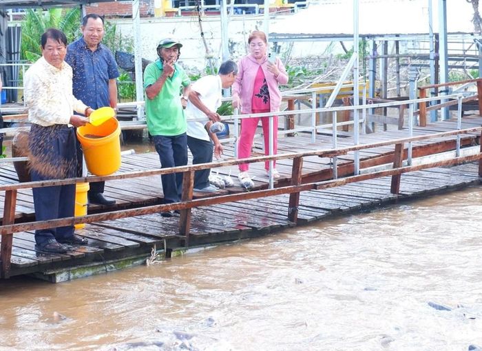 Ông Trương Minh Hải (bên trái),Trưởng ban Tế tự Đình thần An Bình là người tiên phong trong việc thả cá
