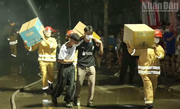 Các lực lượng tham gia hỗ trợ đưa người và tài sản ra khỏi khu vực nguy hiểm. (Ảnh: QUỐC TUẤN)
