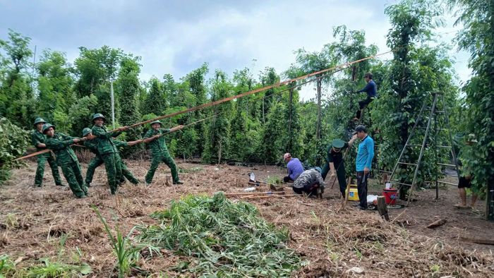 Lực lượng vũ trang giúp nhân dân xã Tân Tiến khắc phục hậu quả thiên tai. (Ảnh: NS)