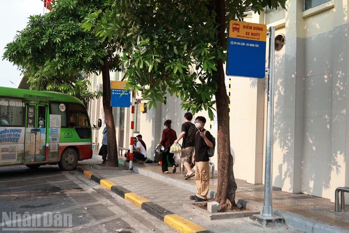 Hành khách chờ xe tại điểm dừng, thuận tiện đón tuyến buýt điện số 83 di chuyển giữa Hà Nội và Hưng Yên.