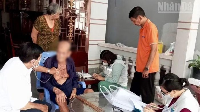 Nhân viên y tế xã Hiệp Phước đến nhà khám sức khỏe cho người cao tuổi. (Ảnh: KHANG ANH)