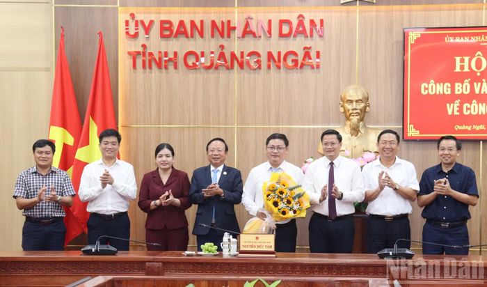 Lãnh đạo tỉnh Quảng Ngãi trao quyết định và tặng hoa chúc mừng đồng chí Võ Minh Vương nhận nhiệm vụ mới. (Ảnh HIỂN CỪ)