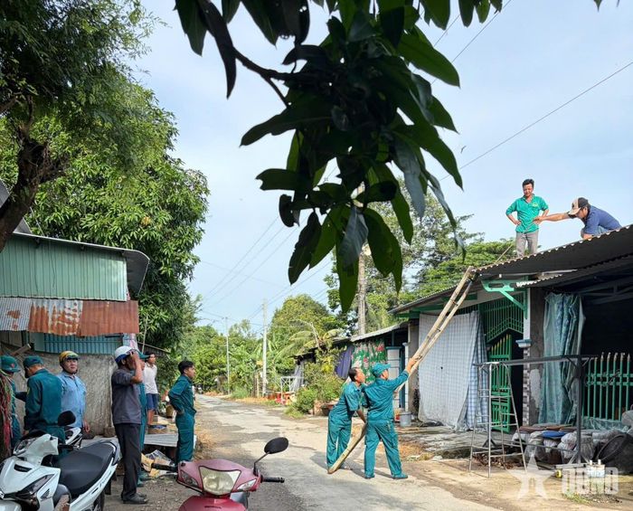 Dân quân cùng người dân chằng chống lại nhà.
