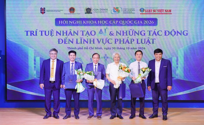  PGS-TS Phạm Văn Song (bìa trái) và PGS-TS, luật sư Bùi Kim Hiếu (bìa phải) tặng hoa cám ơn các diễn giả. 
