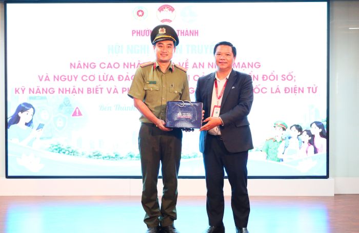 ThS Phan Văn Giang, Bí thư Đảng ủy Trường ĐH Hoa Sen, trao quà lưu niệm của nhà trường, cám ơn Thiếu tá Huỳnh Đỗ Tấn Thịnh. 